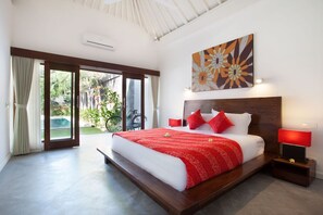 Un dormitorio moderno con una cama grande, una pared de acento roja y vistas al exterior.