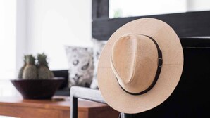 A hat on a metal stand in a room with a wooden table, a patterned cushion, and a cowhide rug. - Lovely Pool Villa | Short Walk to Potato Head Club (Kerobokan Kelod)