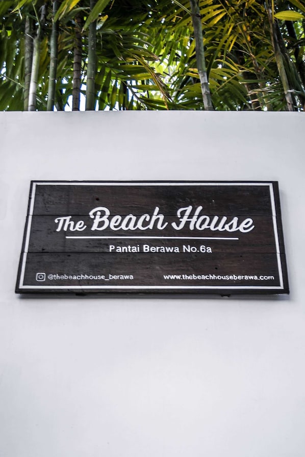 A sign for "The Beach House" with the address "Pantai Berawa No.6a".