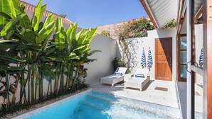A pool area with lounge chairs and a small wall with a door. - Chic Villa Bella | Steps from Eat Street Seminyak (Seminyak)
