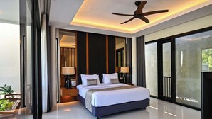 A modern bedroom with a large bed, bedside lamps, a ceiling fan, and a view through large windows. - Closed Living Room Villa The Cabana in Seminyak (Seminyak)