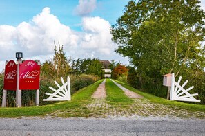 Un chemin menant à une maison avec une boîte aux lettres et un portail.