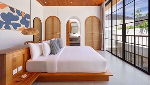 A modern bedroom with a large bed, wooden headboard, and a view through floor-to-ceiling windows.