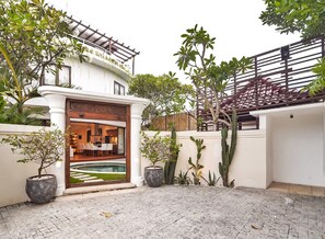 A modern house with a pool, potted plants, and a wooden gate. - Idyllic 2BR Pool | Walk to W Club & Potato Head (Kerobokan Kelod)