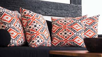 A modern living room with a dark-colored sofa, patterned cushions, and a wooden coffee table.