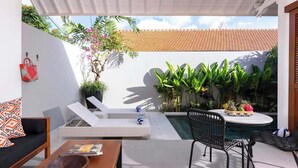 A modern outdoor patio with a pool, lounge chairs, and a dining area. - Cute 1BR Villa 5Mins Walk to Eat Street Seminyak (Seminyak)
