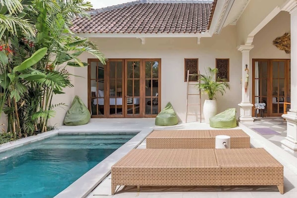 A poolside area with a tiled roof, large windows, and outdoor seating. - Unwind at Seminyak Pool Villa 1Min Walk to Center (Kerobokan Kelod)
