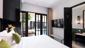 A modern hotel room with a large bed, a TV mounted on the wall, and a view of the outdoor pool area. - 2BR Villa Martini 1 Spacious Walk to FINNS Beach (Dalung)