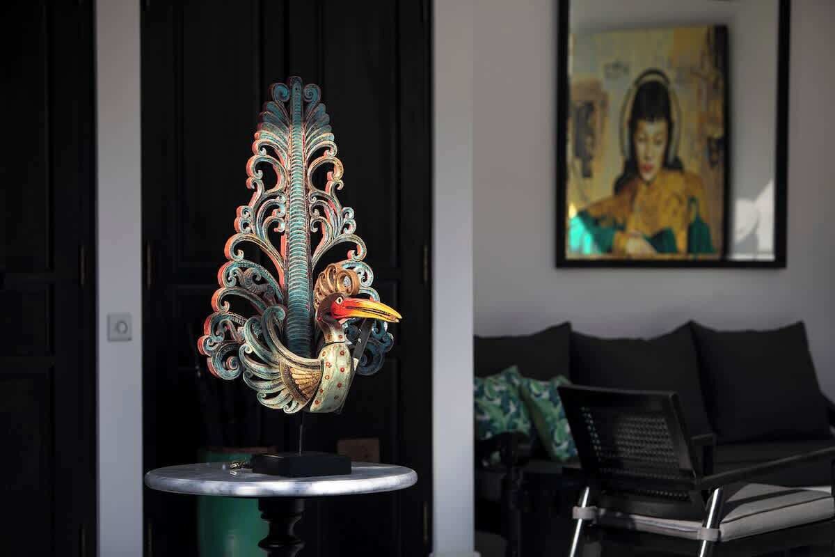 A decorative sculpture on a table in a room with a couch and a framed picture on the wall.