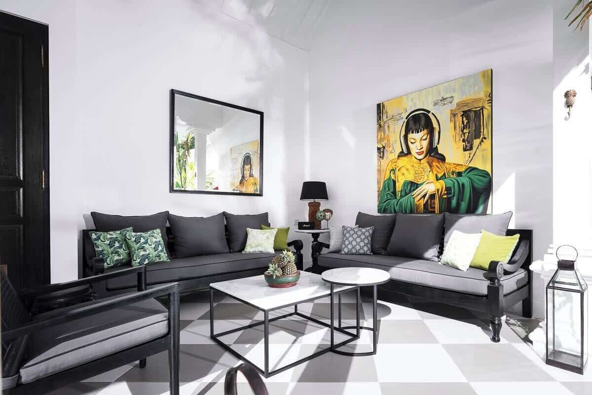 Un salon moderne comprenant un canapé, une table basse, un tableau et une lampe.