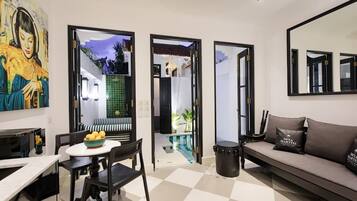Un salon moderne comprenant un coin repas, un canapé et un grand miroir.