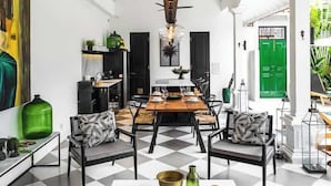 A spacious living area with a checkered floor, a central dining table, and a modern chandelier. - Villa Nago · 2 King Suites · Walk to Potato Head (Kerobokan Kelod)