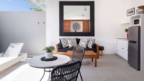 A modern kitchen with a dining area, a ceiling fan, and a large window. - Cozy 1BR Villa Pandi - Walk to Eat Street Seminyak (Seminyak)