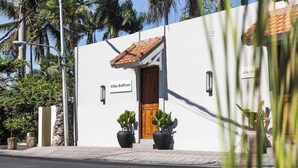 A white building with a wooden door labeled "Villa Saffron." - Villa Saffron – Walk to Seminyak's Best Cafe Shop (Kerobokan Kelod)
