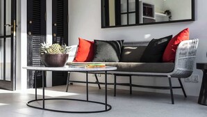 A modern living area with a sofa, a round coffee table, and a potted plant. - Villa Saffron – Walk to Seminyak's Best Cafe Shop (Kerobokan Kelod)