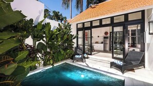 A modern house with a swimming pool, large windows, and tropical plants. - Villa Saffron – Walk to Seminyak's Best Cafe Shop (Kerobokan Kelod)