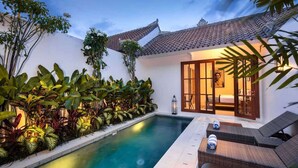 A private pool area with lounge chairs, a well-maintained garden, and a traditional tiled roof. - Walk around Seminyak Petitenget from 1BR PoolVilla (Kerobokan Kelod)