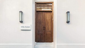 A wooden double door with a sign reading "Villa Soleh" above it, flanked by two wall-mounted lanterns. - Comfort 3BR Soleh Walk to Shops & Beach Seminyak (Kerobokan Kelod)