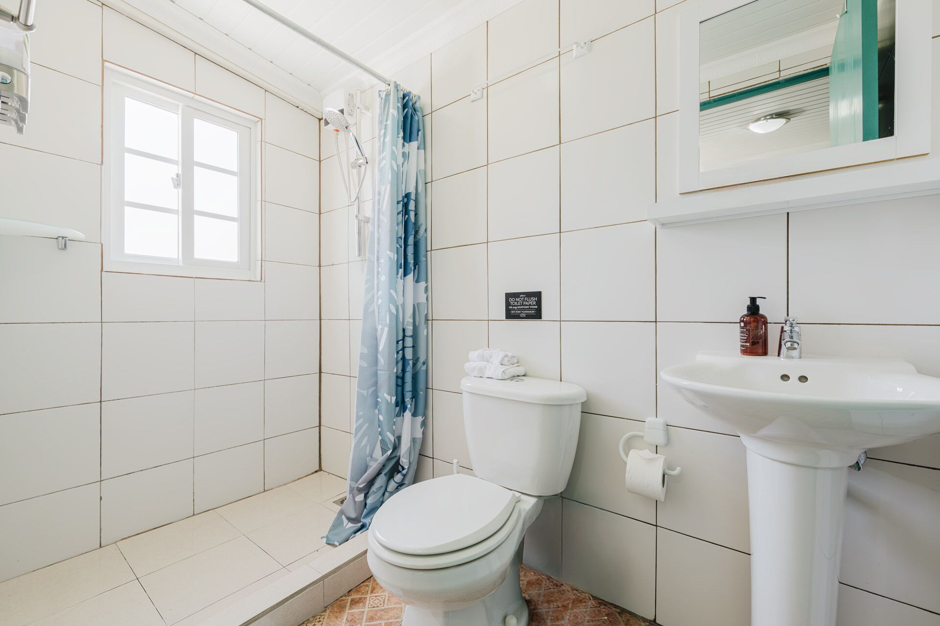 A bathroom with a shower, toilet, and sink.