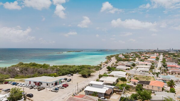 Un quartier résidentiel situé sur la côte, avec des maisons, un parking et une vue dégagée sur l’océan.