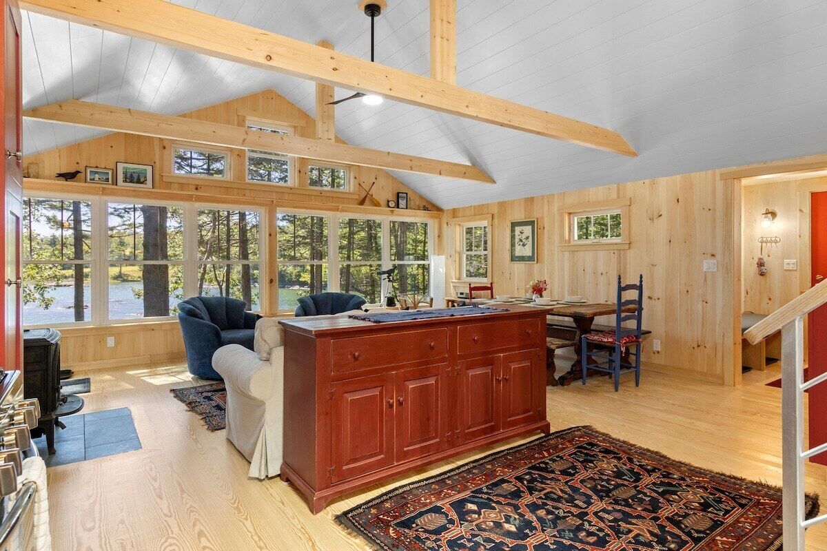 A spacious room with a large wooden dining table, a sofa, and a fireplace.