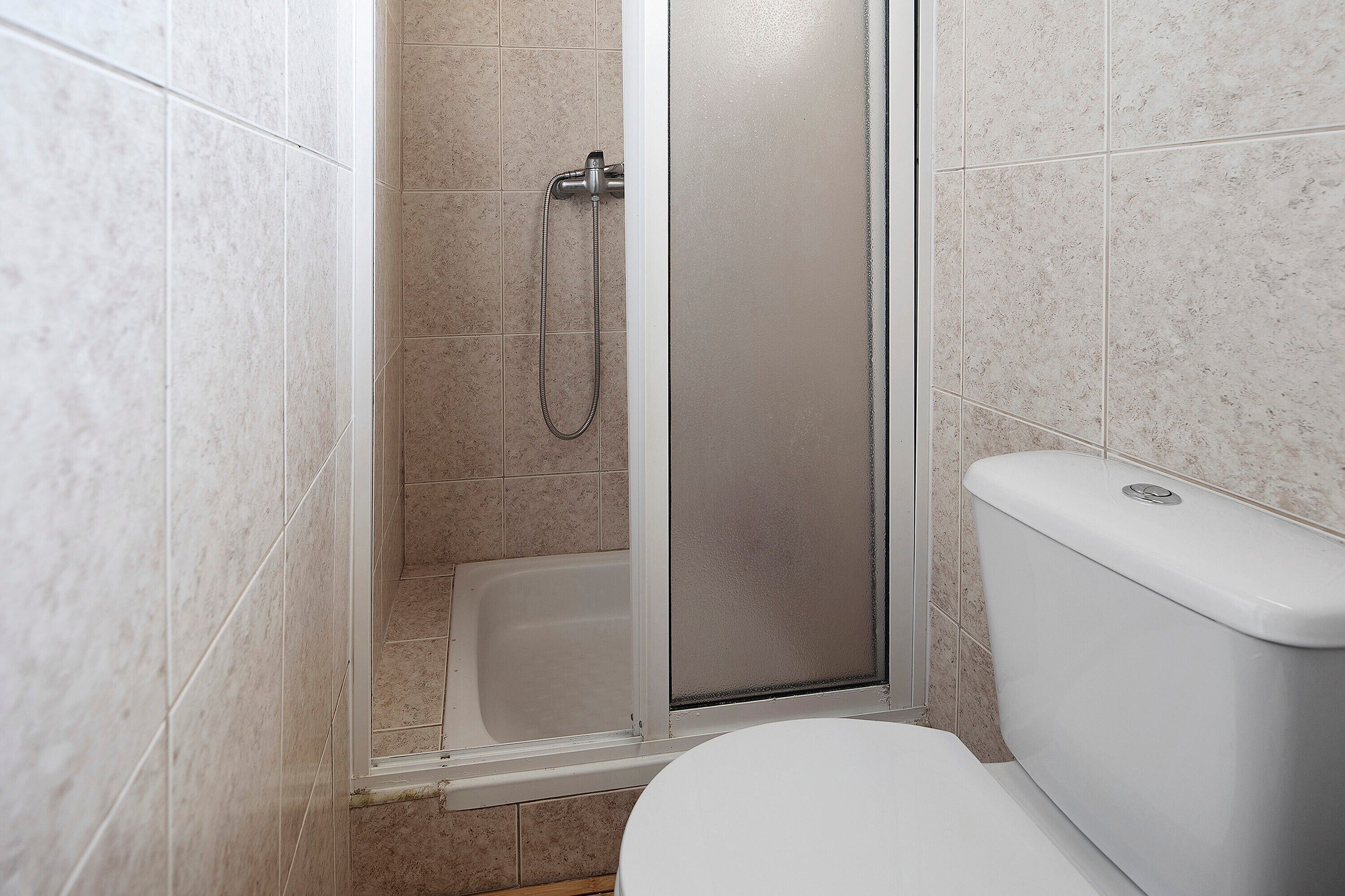 A bathroom with a shower enclosure, a toilet, and a bathtub.
