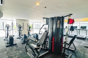 A gym with various exercise equipment, including treadmills and weight machines. - Luxurious Penhouse Cross City of Dreams OKADA SOLAIRE MOA (Paranaque)