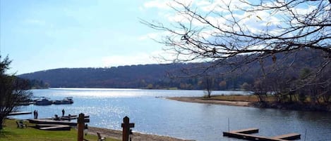 Vista de un lago con un muelle, sillas y una valla de madera.