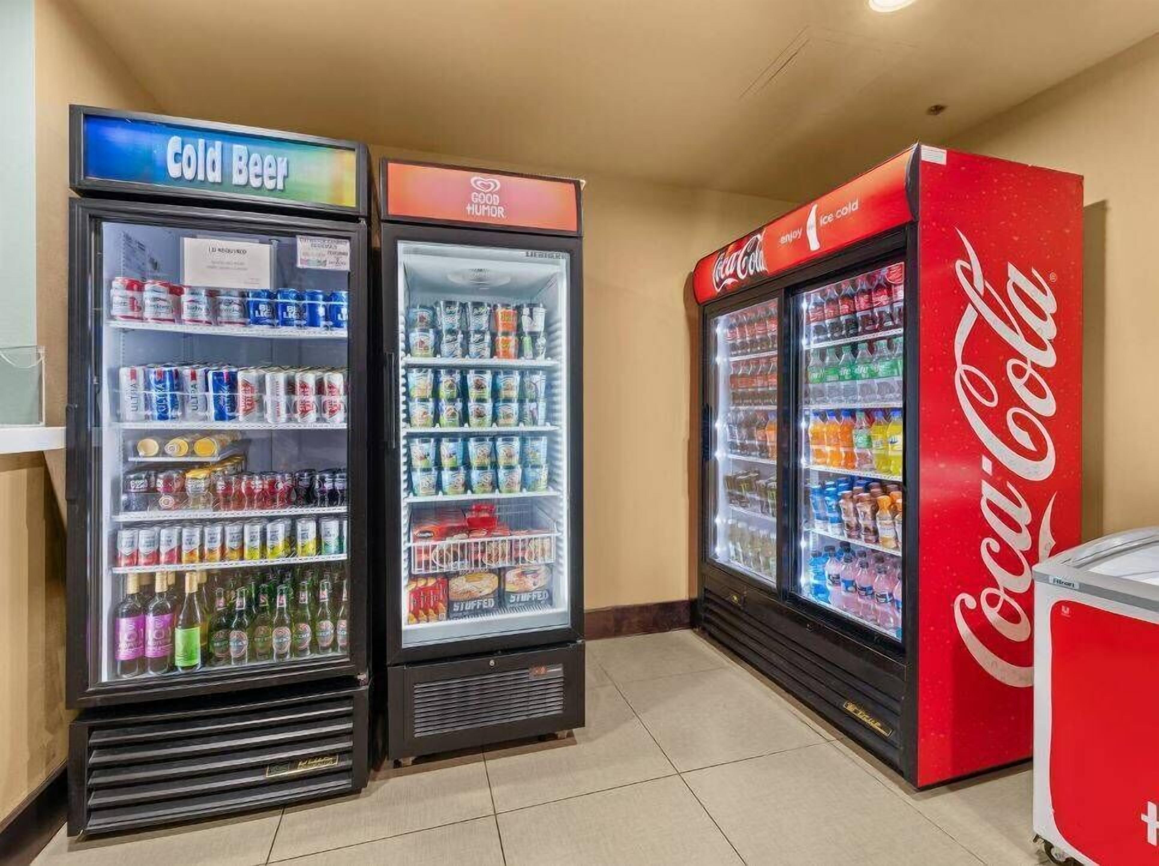A vending machine area with a Coca-Cola cooler and two refrigerated beverage dispensers labeled "Cold Beer" and "Good Humor."