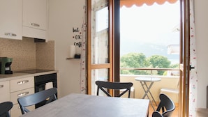 Una cocina con comedor, cafetera y vistas a la vegetación a través de una ventana.
