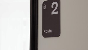 A sign with the number 2 and the name "RoMa" on a wall.