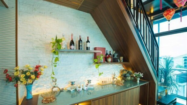 Zona de bar moderna con encimera de vidrio, botellas de vino y elementos decorativos.