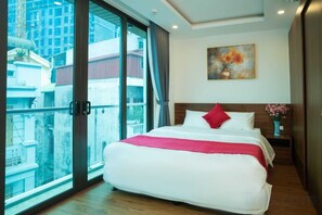 A hotel room with a large bed, a painting on the wall, and a view through a glass door. - Atypik Vietnam House (Hanoi)