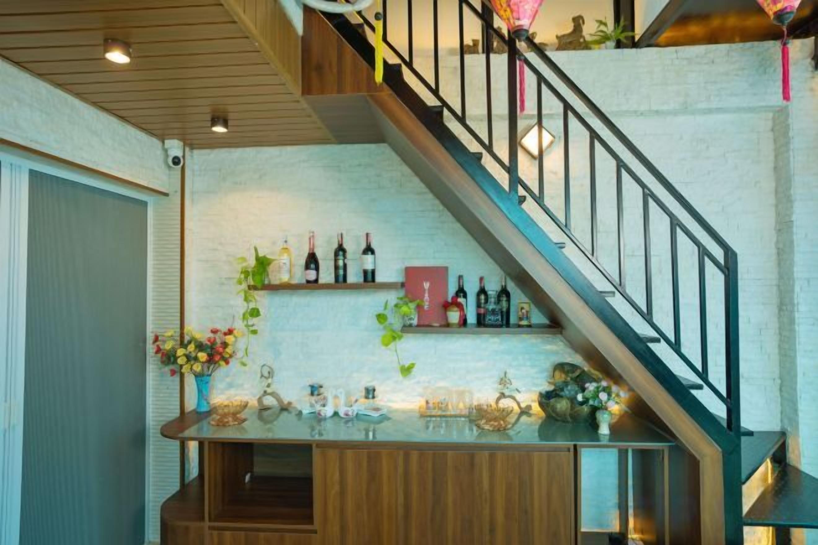 A staircase with a wooden railing leading to a landing with a wine rack and a bar area.