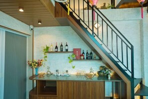 Una scala con ringhiera in legno conduce a un pianerottolo con una cantina e un’area bar.