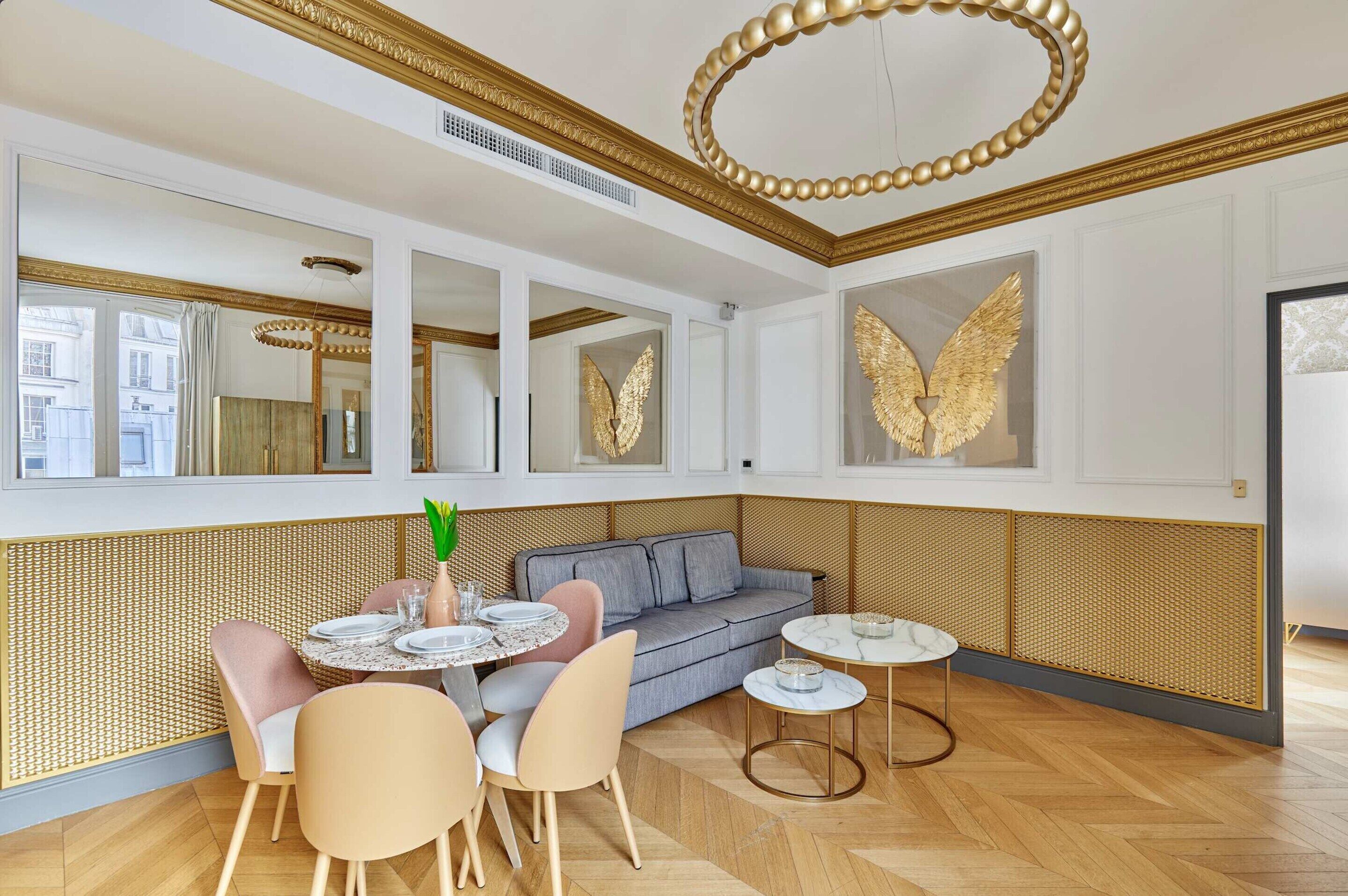 A modern interior with a dining area, sofa, and decorative wall art.