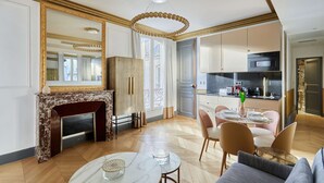 Una sala de estar moderna con chimenea, comedor y cocina.