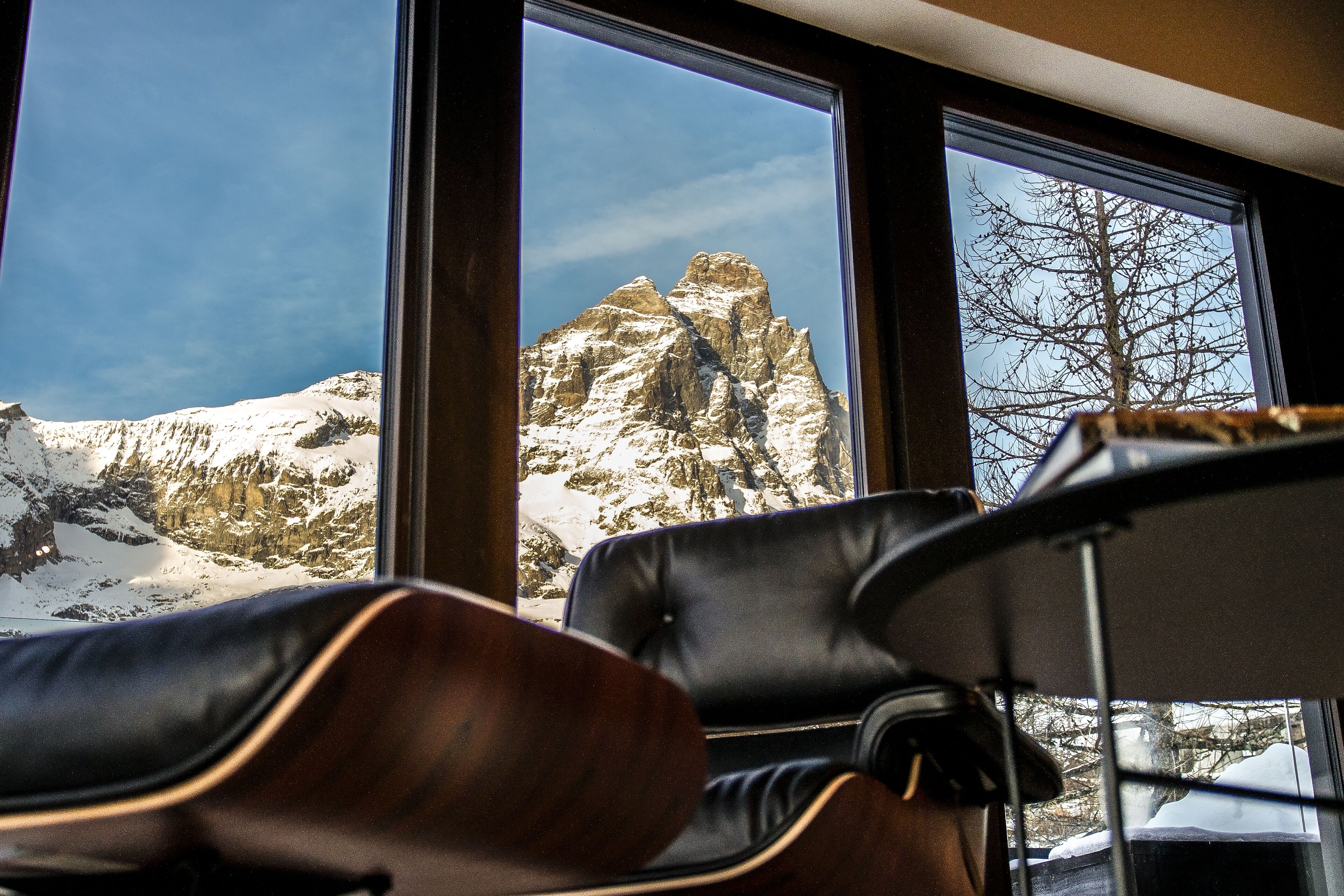 A room with a view of snow-covered mountains through large windows.