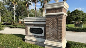 A sign with "CARRIAGE POINTE" on a brick structure with a decorative top. - Luxury Townhome on reunion resort (Kissimmee)