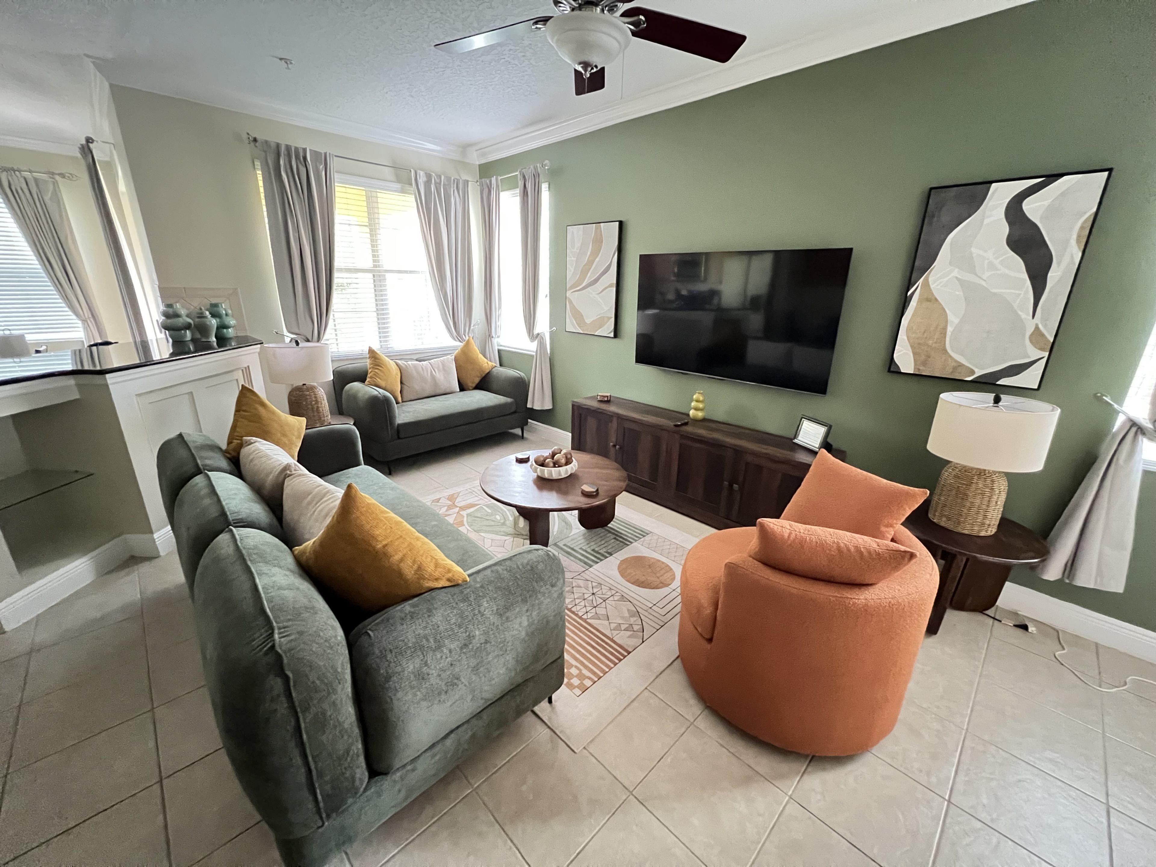 A living room with a sofa, armchair, coffee table, and a TV.