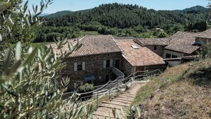 A stone building with a tiled roof, surrounded by olive trees and hills. - Le mas de Jeanne (Rocher)