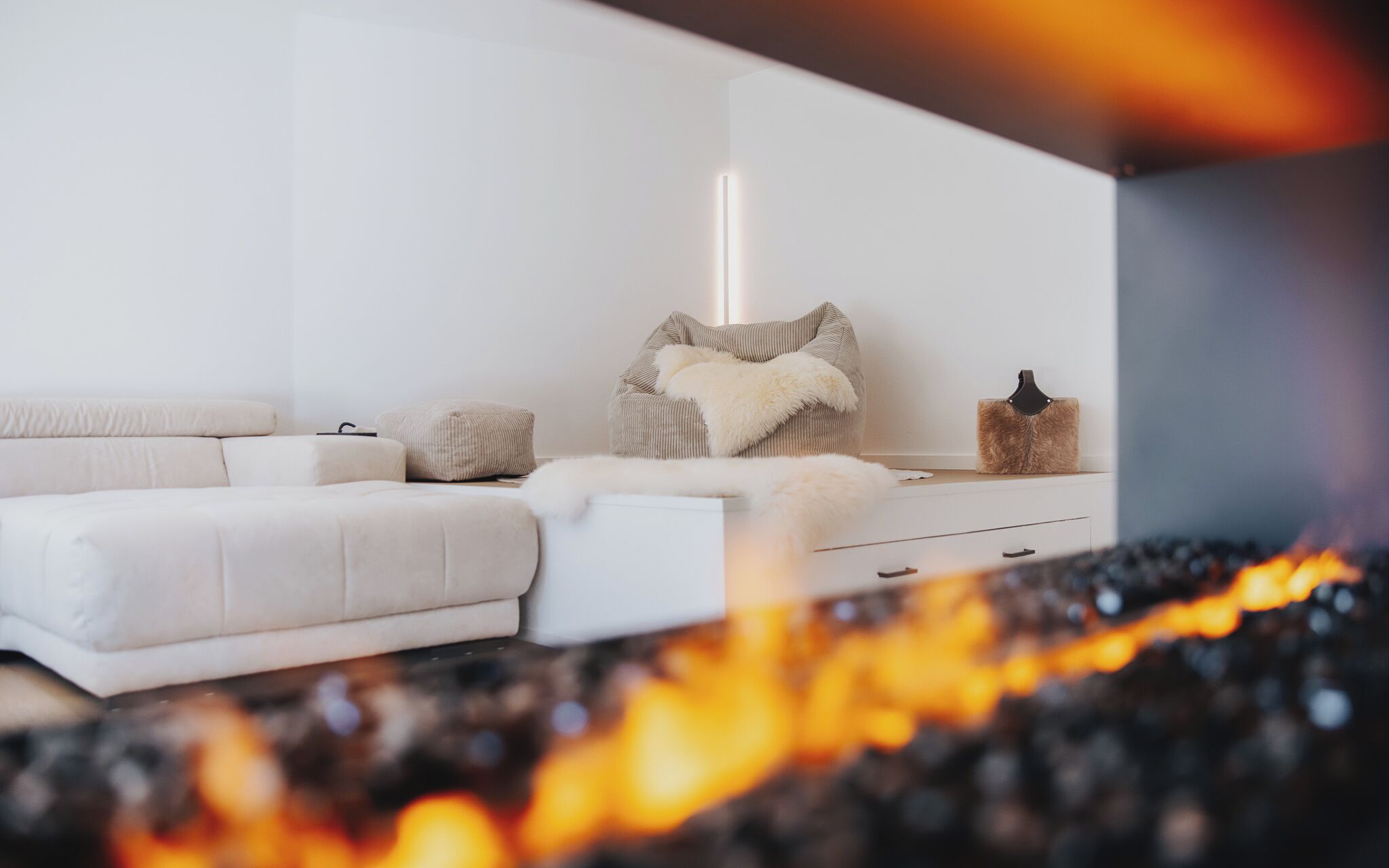 Ein modernes Wohnzimmer mit einer Couch, Hocker und einem Zierstuhl.