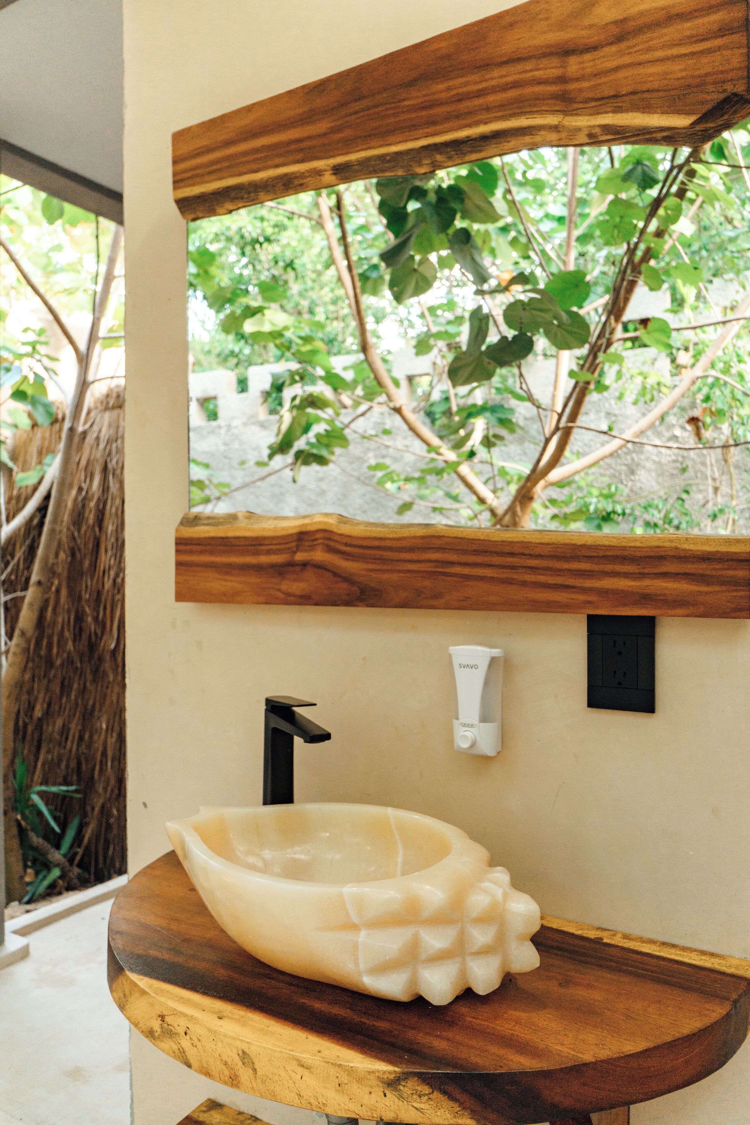 Une salle de bain avec un meuble-lavabo en bois, un lavabo blanc et un miroir au-dessus de l’évier.