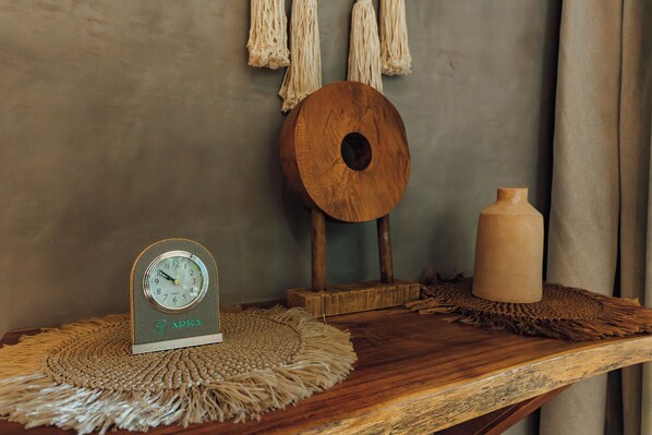 A wooden table with a woven placemat, a wooden clock, a wooden bowl, and a vase. - ARKA TULUM (Tulum)