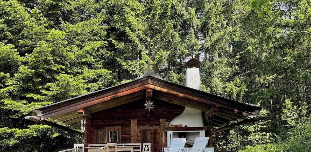 Eine rustikale Holzhütte mit geneigtem Dach und Schornstein.
