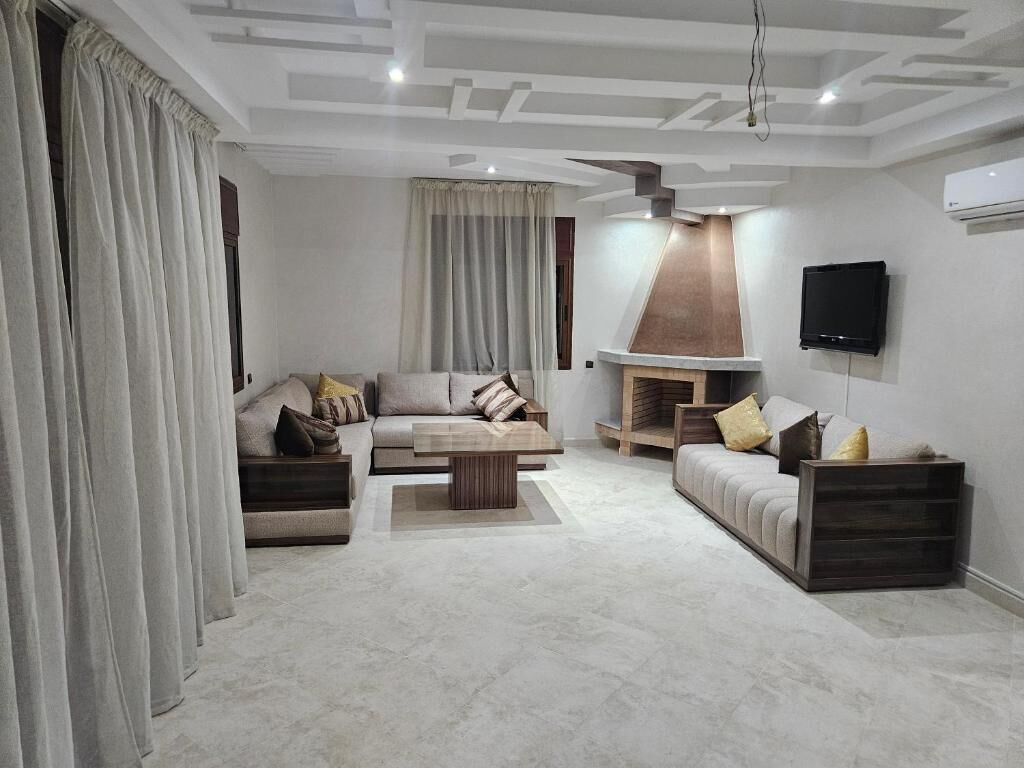 A modern living room with a sofa set, a coffee table, and a fireplace.