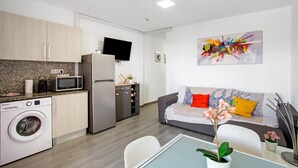 Una cocina moderna con lavadora, microondas y refrigerador.