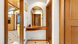 Un couloir doté d’un plancher en bois, d’un comptoir en bois et d’une porte avec un miroir.