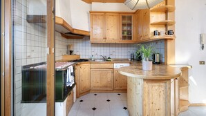 Une cuisine avec des meubles de rangement en bois, une cuisinière et un évier.