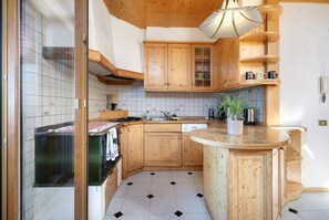 Une cuisine avec des meubles de rangement en bois, une cuisinière et un évier.